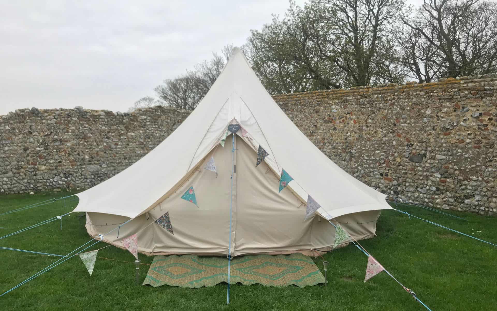 Traditional canvas bell tent set up for camping at Barn Drift, Norfolk.