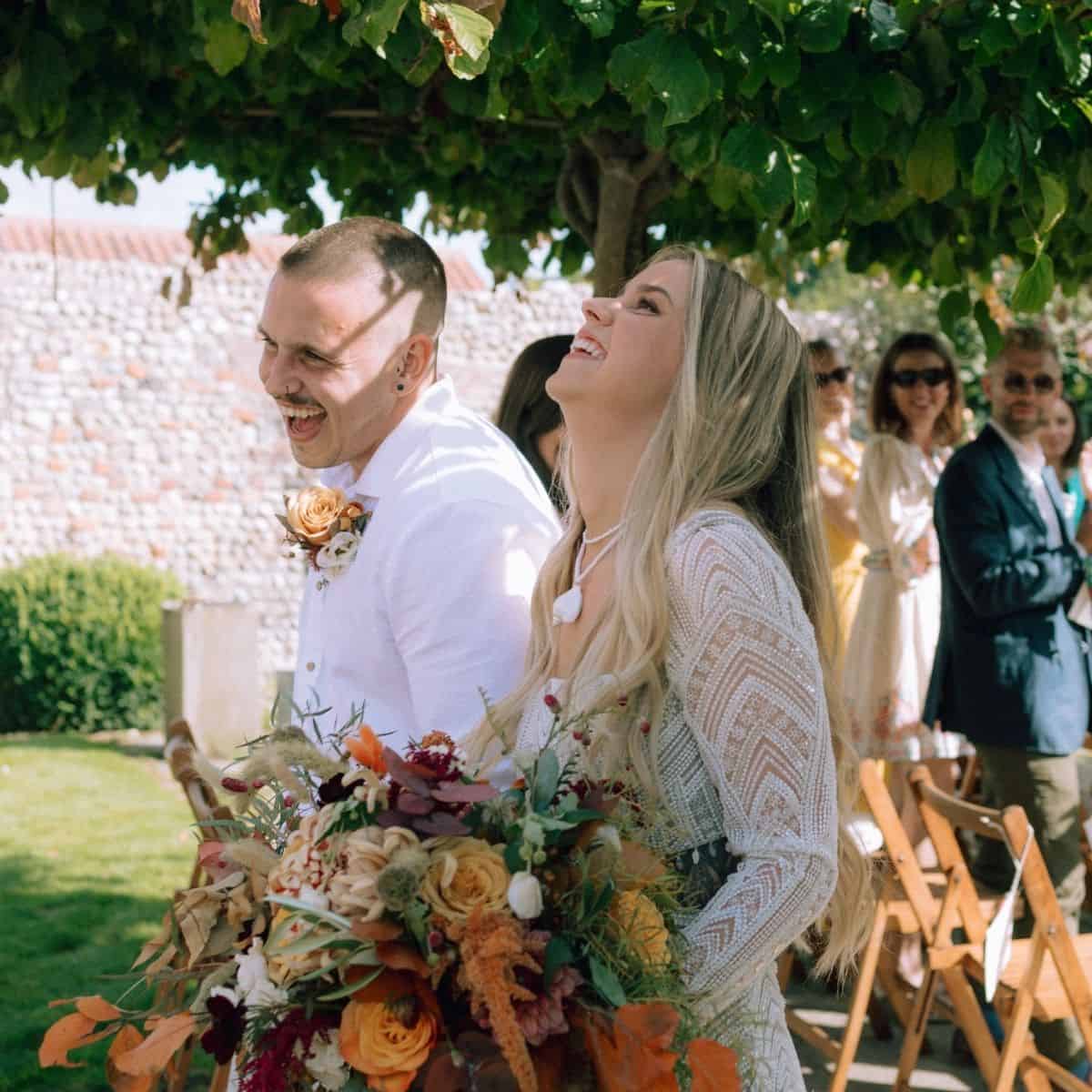 Beautiful garden wedding at Barn Drift Norfolk with happy bride and groom under lush greenery.