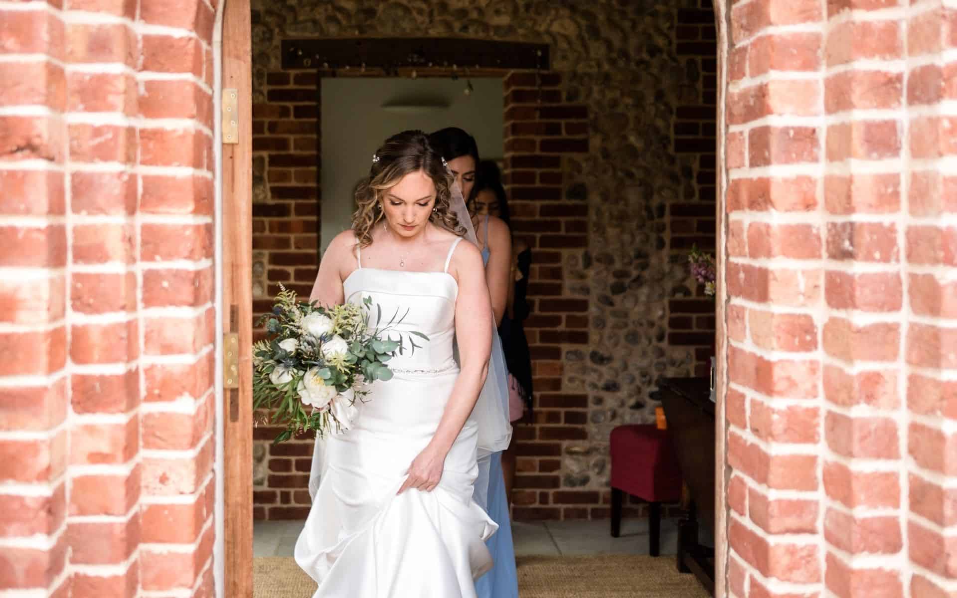 Elegant bride holding a bouquet at Barn Drift Norfolk wedding venue, perfect for small wedding celeb.