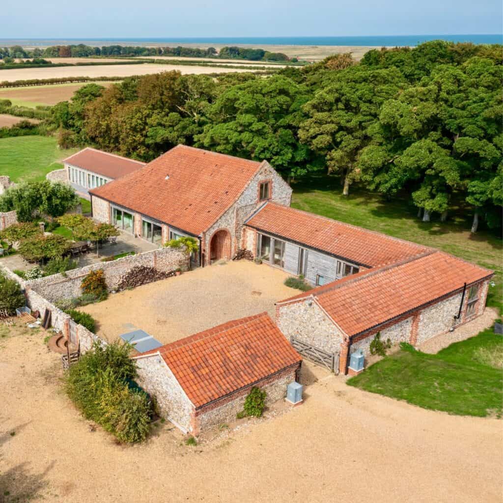 Rustic barn surrounded by lush woodland and fields, ideal for woodland wedding ceremonies in Norfolk.