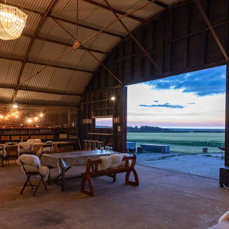 Rustic barn interior with scenic Norfolk countryside view for woodland wedding events.