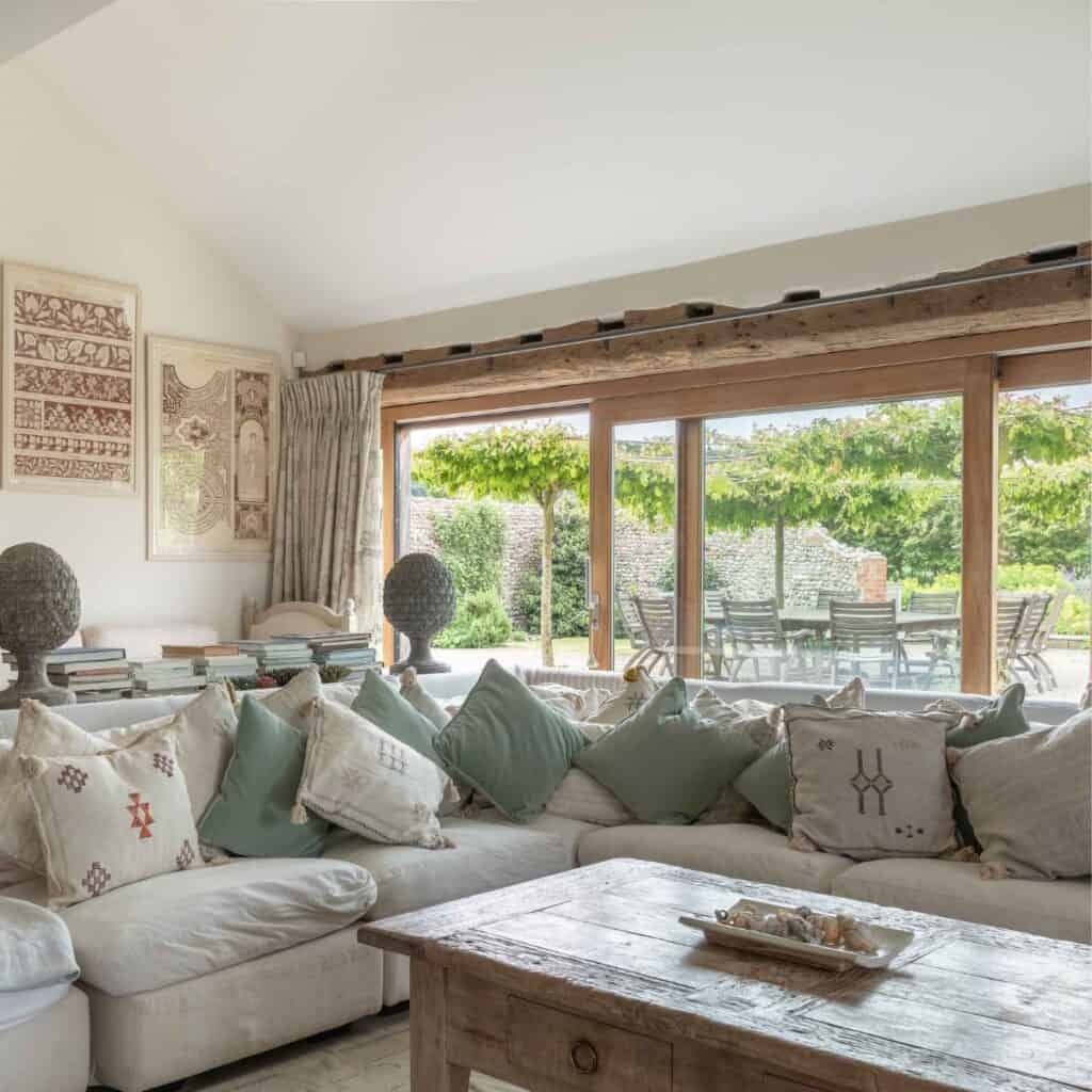 Cosy Norfolk living room with large glass doors opening to garden views.